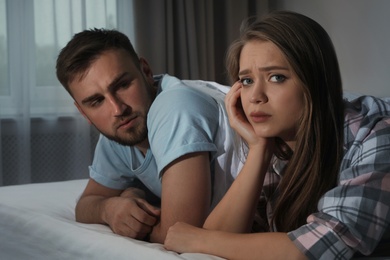 Photo of Young couple with relationship problems in bed at nighttime