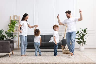 Photo of Happy family dancing and having fun in living room