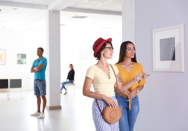 Photo of Young women at exhibition in art gallery