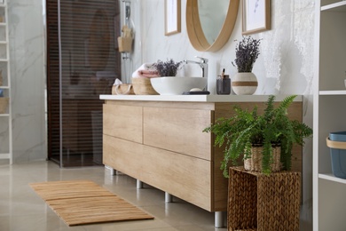 Photo of Bathroom interior with counter and houseplant. Idea for design