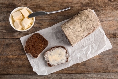 Photo of Flat lay composition with bread and butter on wooden table