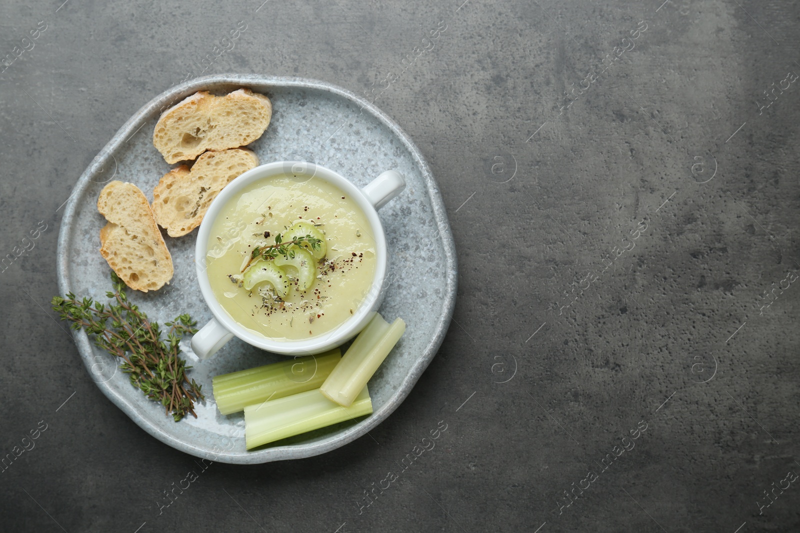 Photo of Delicious celery soup on gray table, top view. Space for text