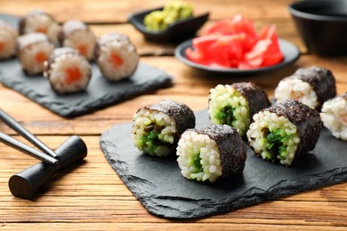 Photo of Tasty sushi rolls served on wooden table