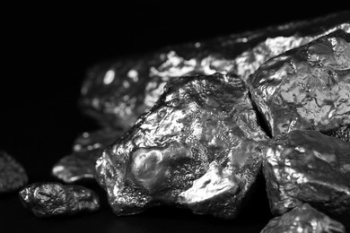 Pile of silver nuggets on black background, closeup