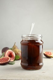 Photo of Jar of tasty sweet fig jam on light table