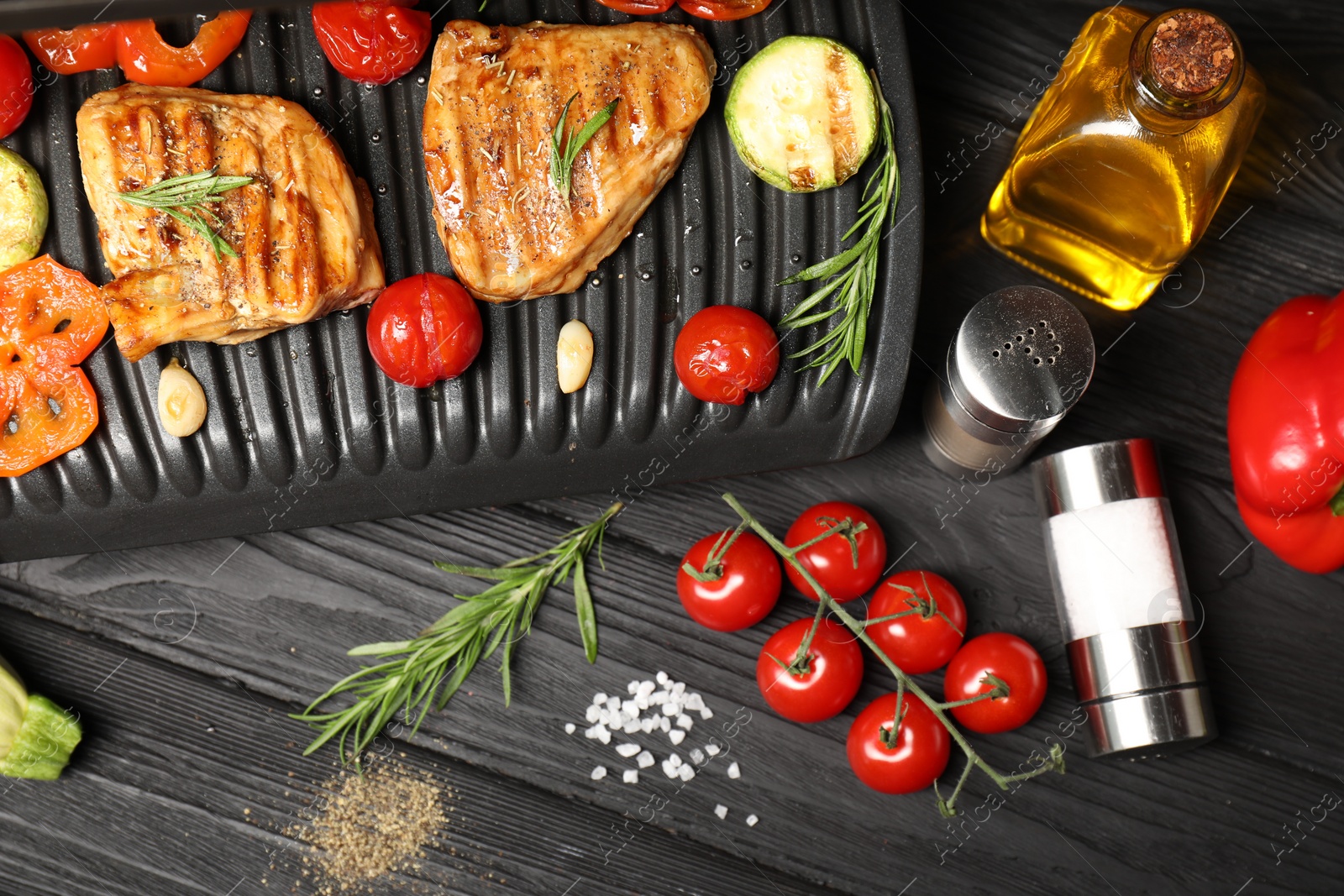 Photo of Flat lay composition with electric grill and different products on black wooden table