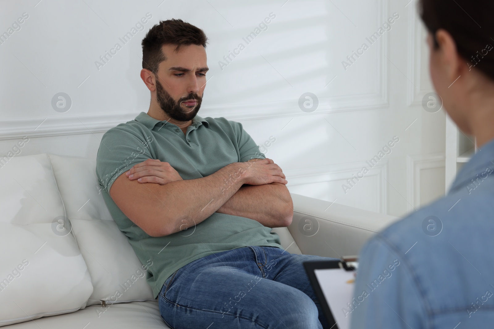 Photo of Unhappy man having session with his therapist indoors