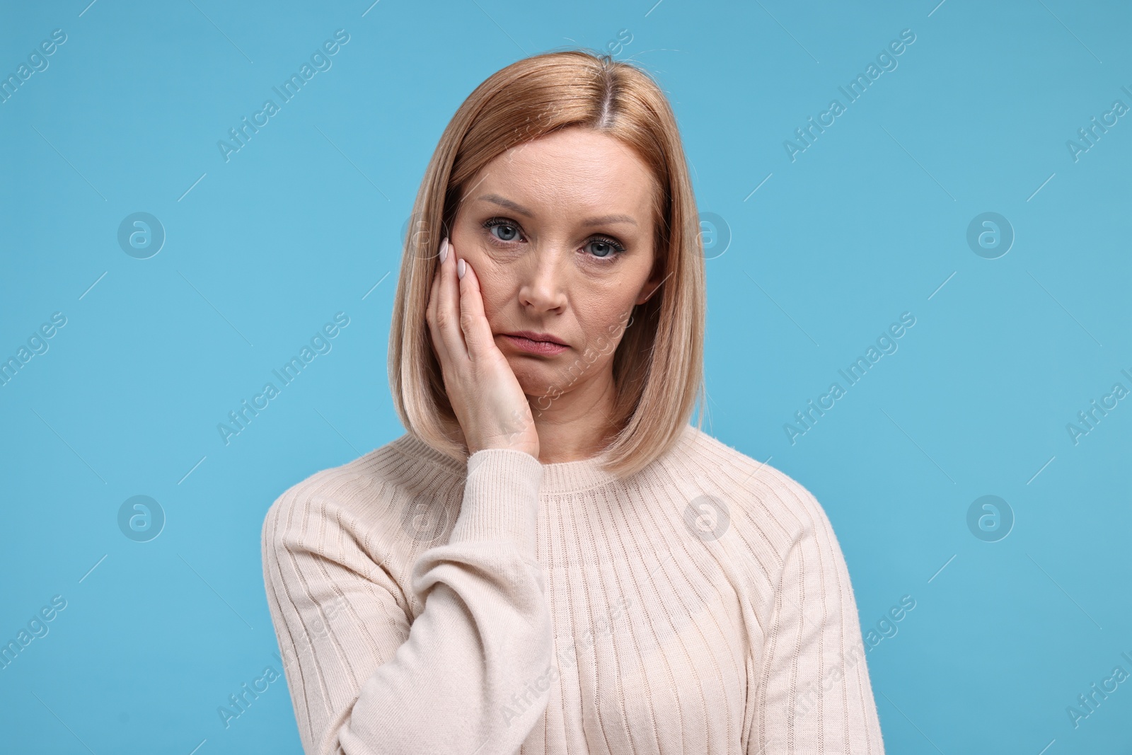 Photo of Portrait of sad woman on light blue background