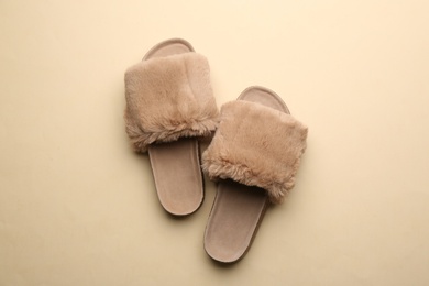 Photo of Pair of soft slippers on beige background, flat lay