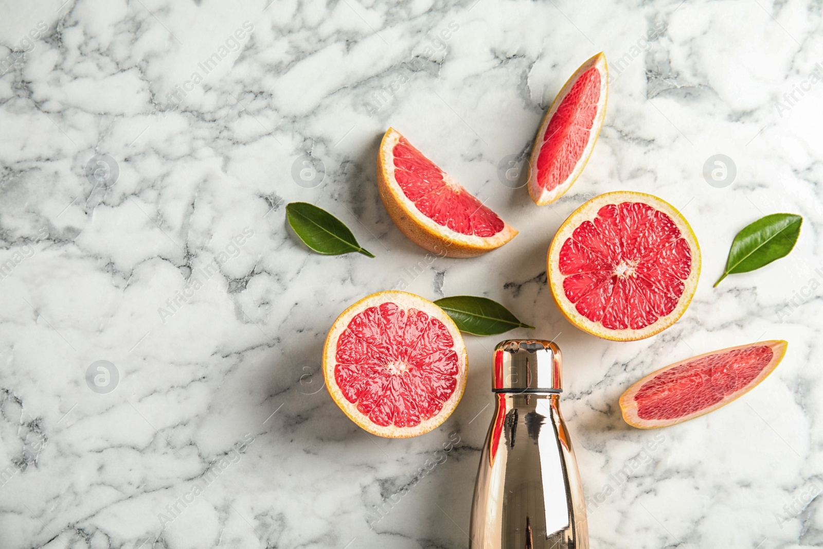 Photo of Flat lay composition with grapefruits, bottle of juice and space for text on marble background