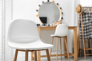 Photo of Stylish white chair in makeup room interior. Space for text