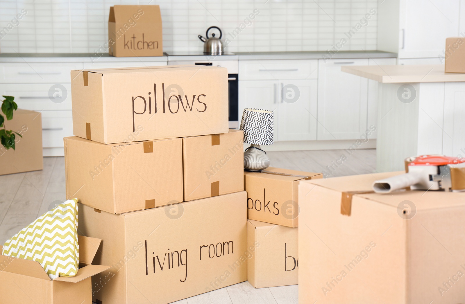 Photo of Many moving boxes in kitchen. Space for text