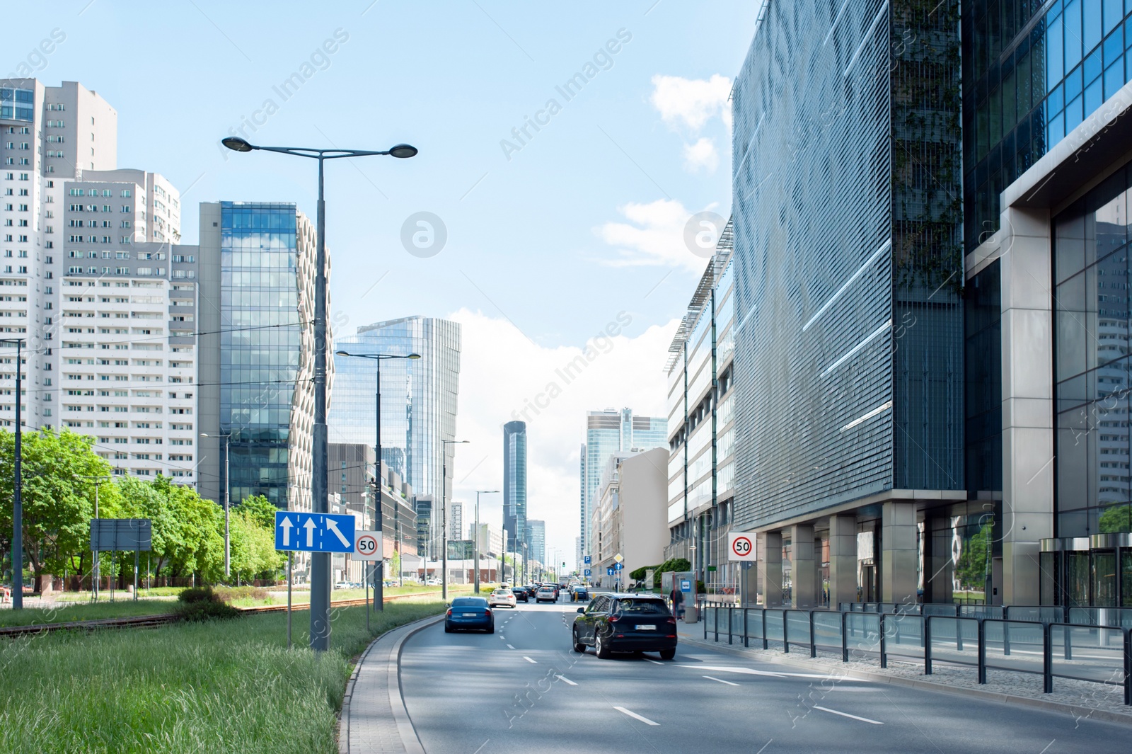 Photo of Road, cars and beautiful buildings on cloudy day in city