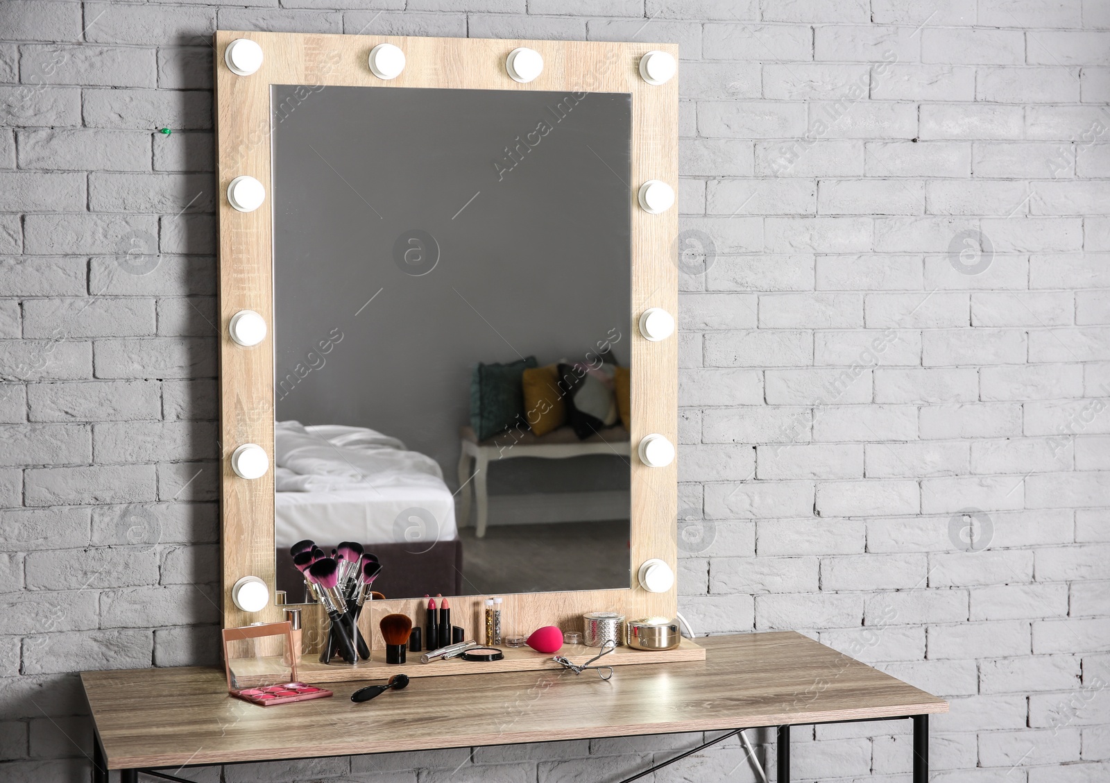 Photo of Dressing room interior with stylish mirror and set of makeup products