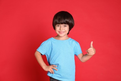 Photo of Portrait of cute little boy on red background