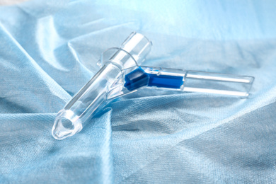 Photo of Anoscope on light blue fabric. Hemorrhoid treatment