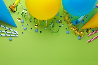 Photo of Different accessories for birthday party on green background, flat lay. Space for text