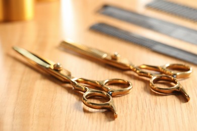 Hairdresser tools. Different scissors and combs on wooden table, closeup