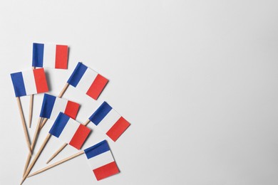 Photo of Small paper flags of France on light background, flat lay. Space for text