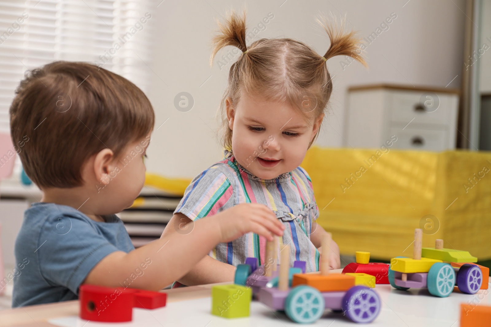 Photo of Little children playing with construction set at table
