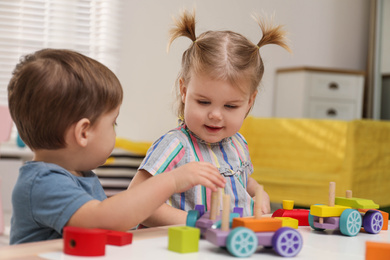 Little children playing with construction set at table