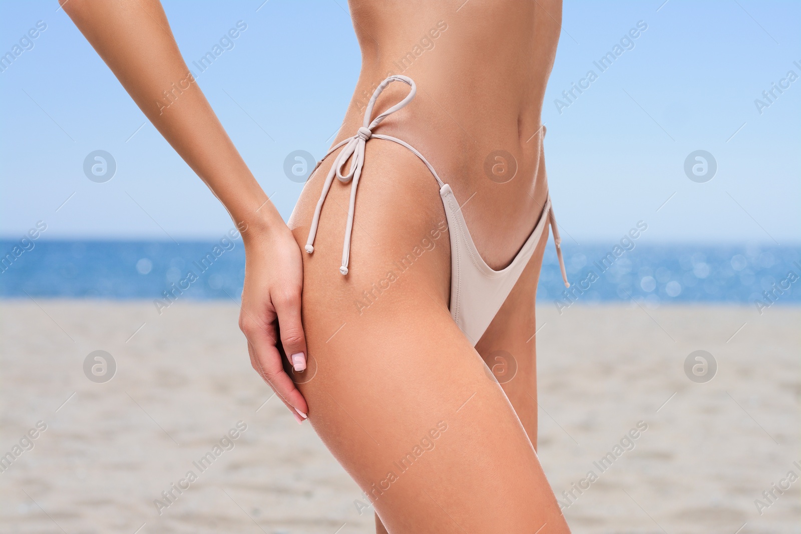 Image of Woman in stylish bikini on sandy beach near sea, closeup