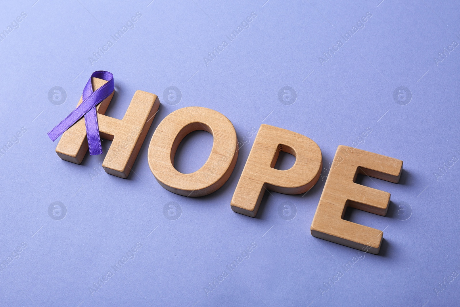 Photo of Composition with purple ribbon and word HOPE on violet background. Domestic violence awareness