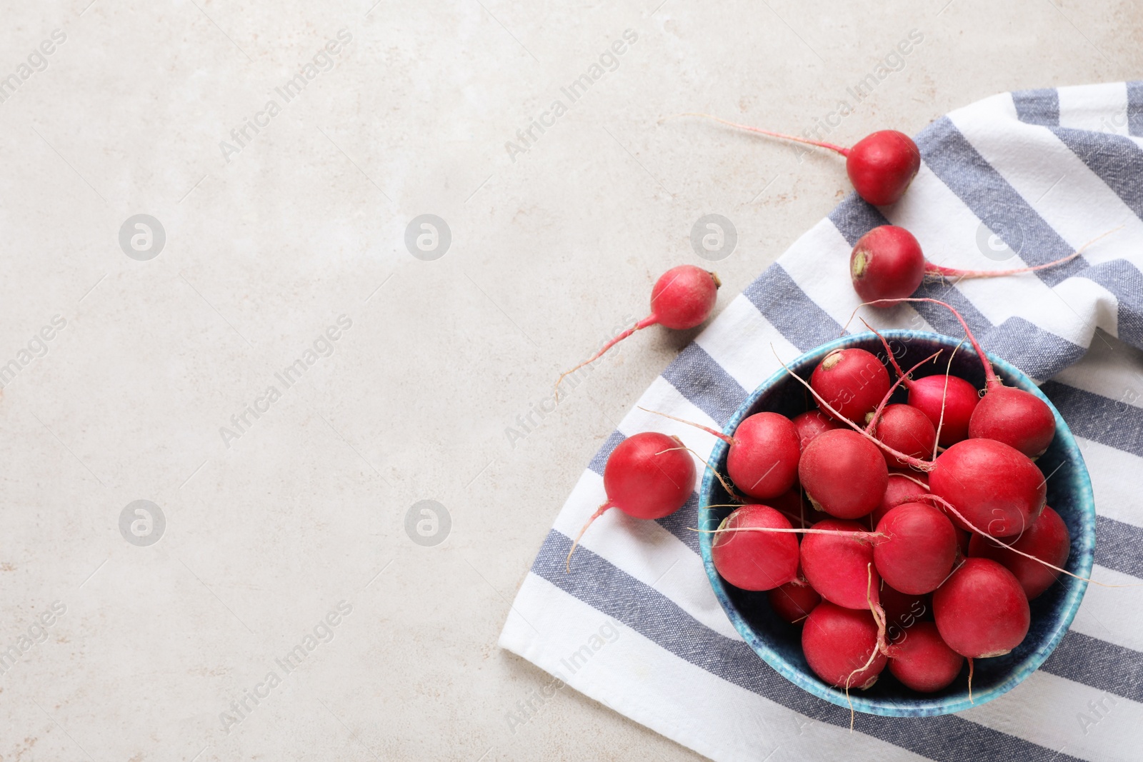 Photo of Bowl with fresh ripe radishes on light table, flat lay. Space for text