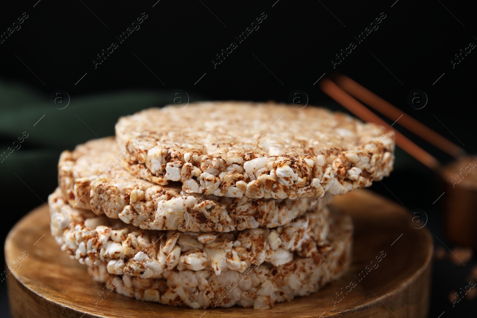 Photo of Stack of crunchy buckwheat cakes on wooden plate, closeup