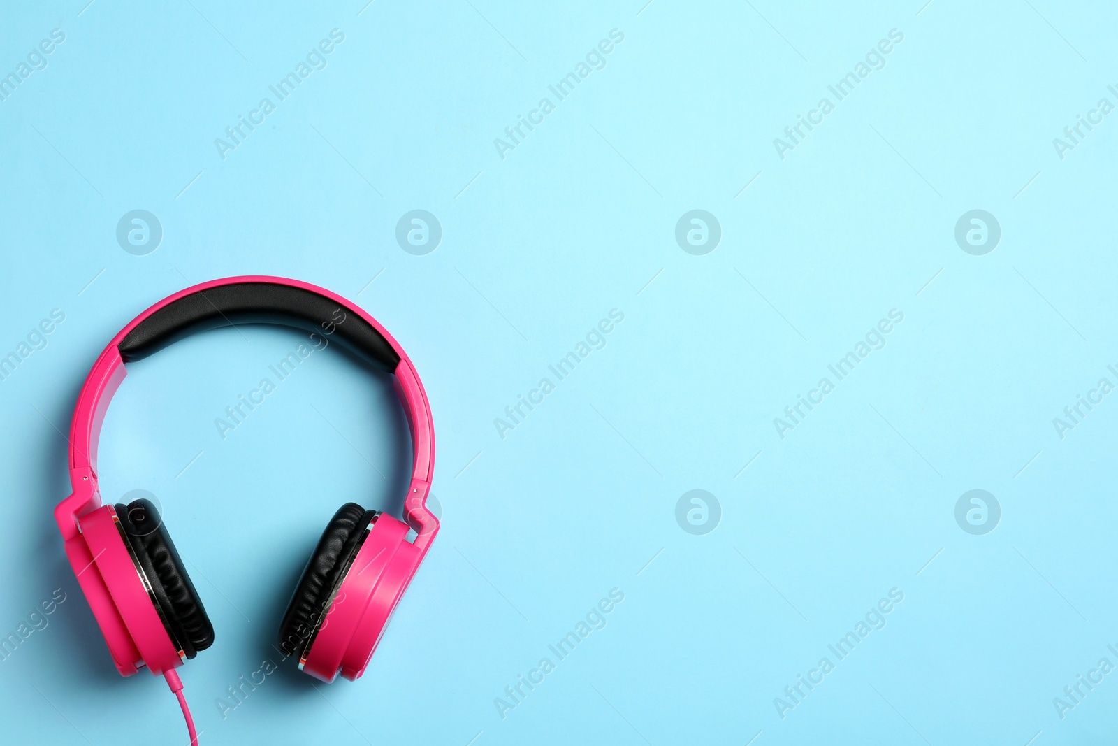 Photo of Stylish headphones on color background, top view. Space for text