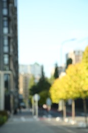 Blurred view of quiet city street with buildings and beautiful trees