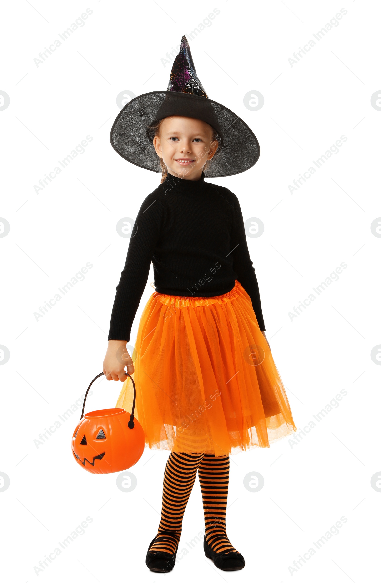 Photo of Cute little girl with pumpkin candy bucket wearing Halloween costume on white background