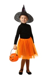 Cute little girl with pumpkin candy bucket wearing Halloween costume on white background