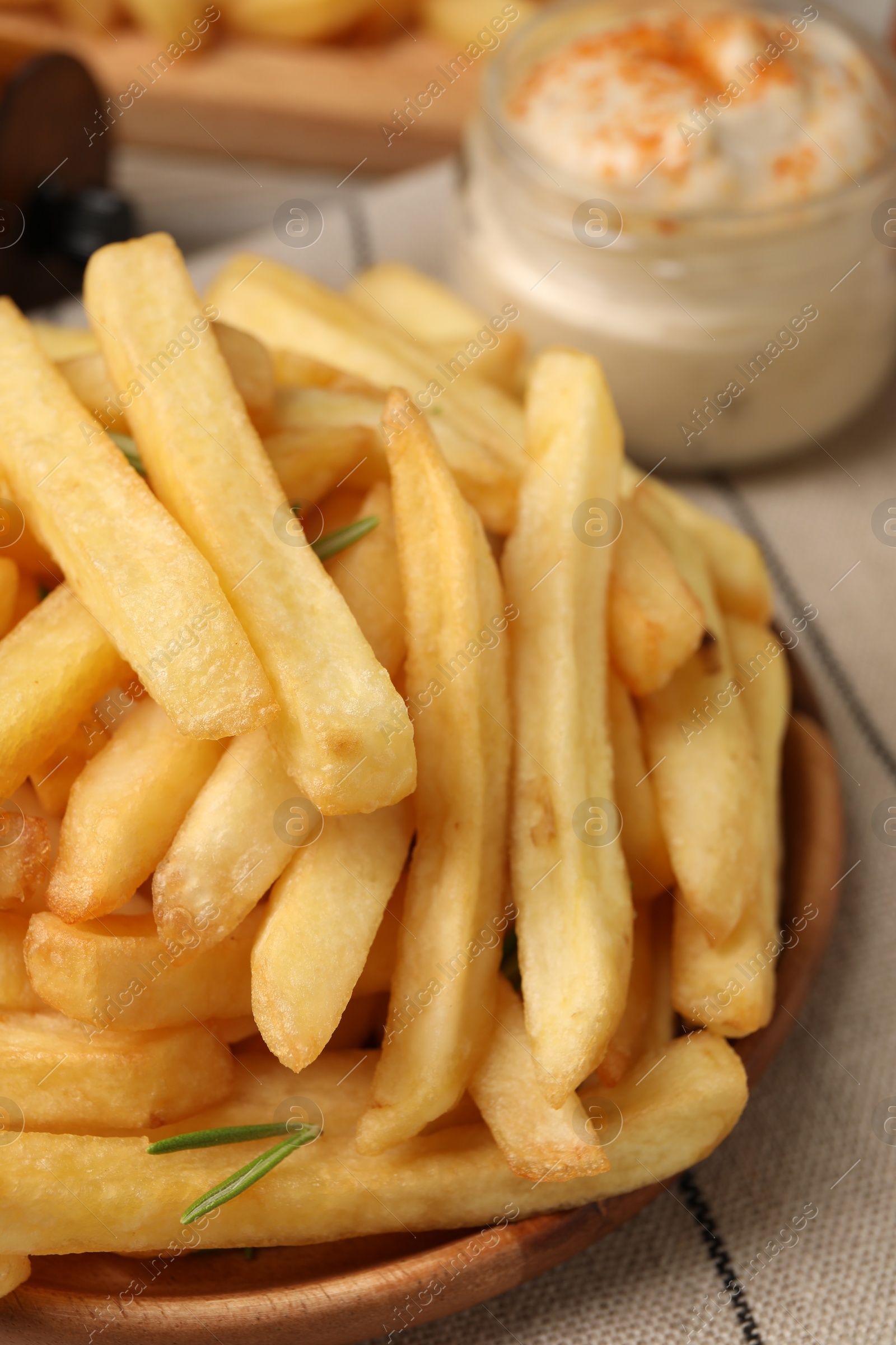Photo of Delicious french fries served with sauce on table, closeup