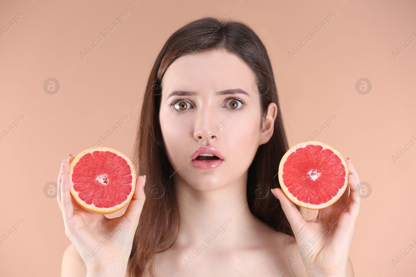 Photo of Teenage girl with acne problem holding grapefruit against color background