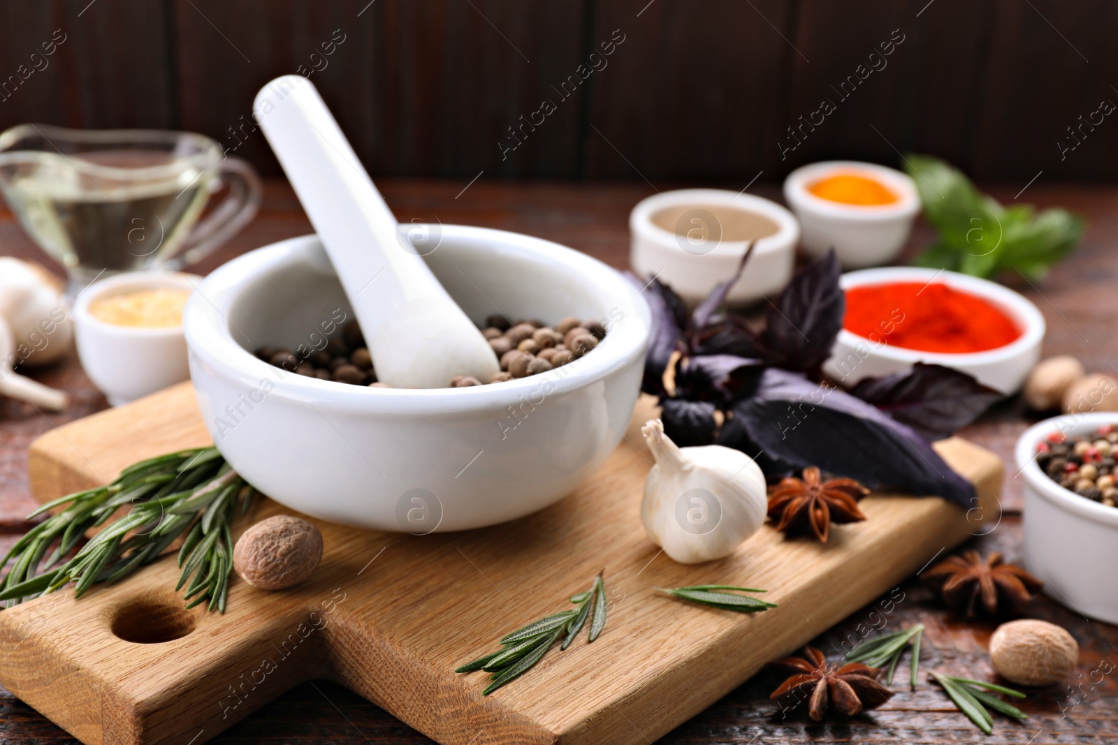 Photo of Mortar and different spices on wooden table