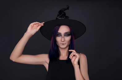 Photo of Mysterious witch wearing hat on black background