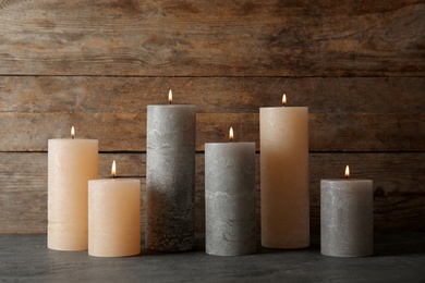 Many alight scented wax candles on table