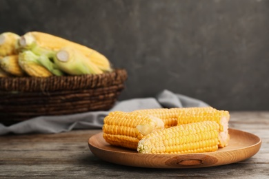 Photo of Plate with tasty sweet corn on wooden table