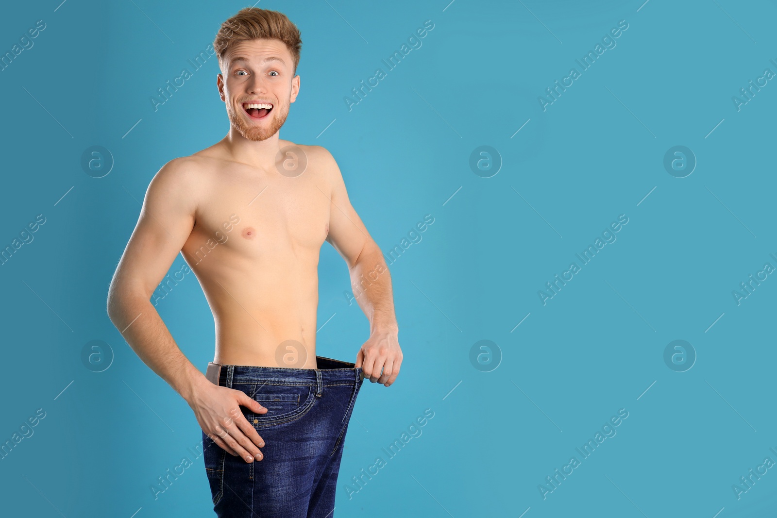Photo of Handsome man in oversized jeans on color background. Space for text