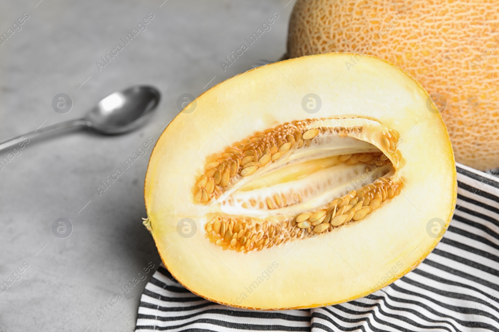 Photo of Tasty cut ripe melon on grey table, closeup