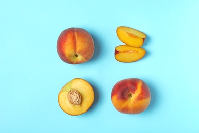 Sweet juicy peaches on light blue background, flat lay