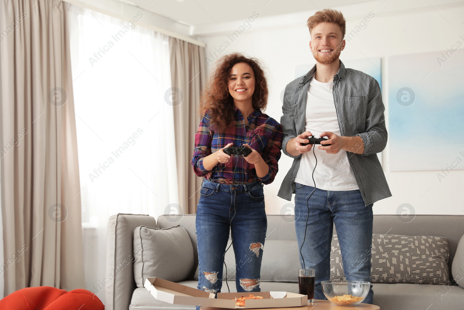 Photo of Young couple playing video games at home