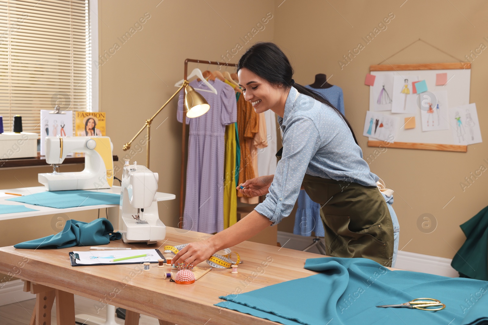 Photo of Dressmaker working at table in modern atelier