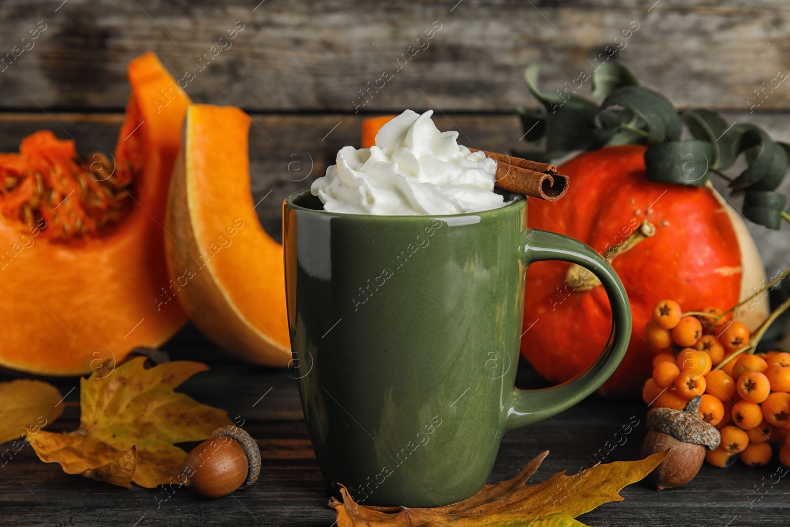 Photo of Composition with pumpkin spice latte  in cup on wooden table