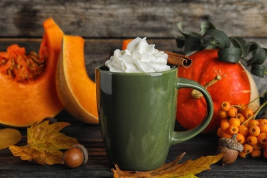 Photo of Composition with pumpkin spice latte  in cup on wooden table