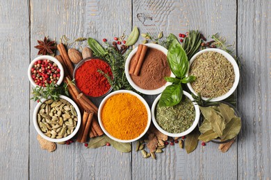 Photo of Different natural spices and herbs on grey wooden table, flat lay