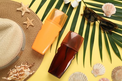 Photo of Sun protection products and beach accessories on yellow background, flat lay