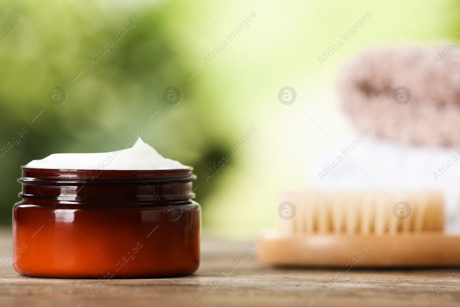 Photo of Jar of body care product on table against blurred background. Space for text