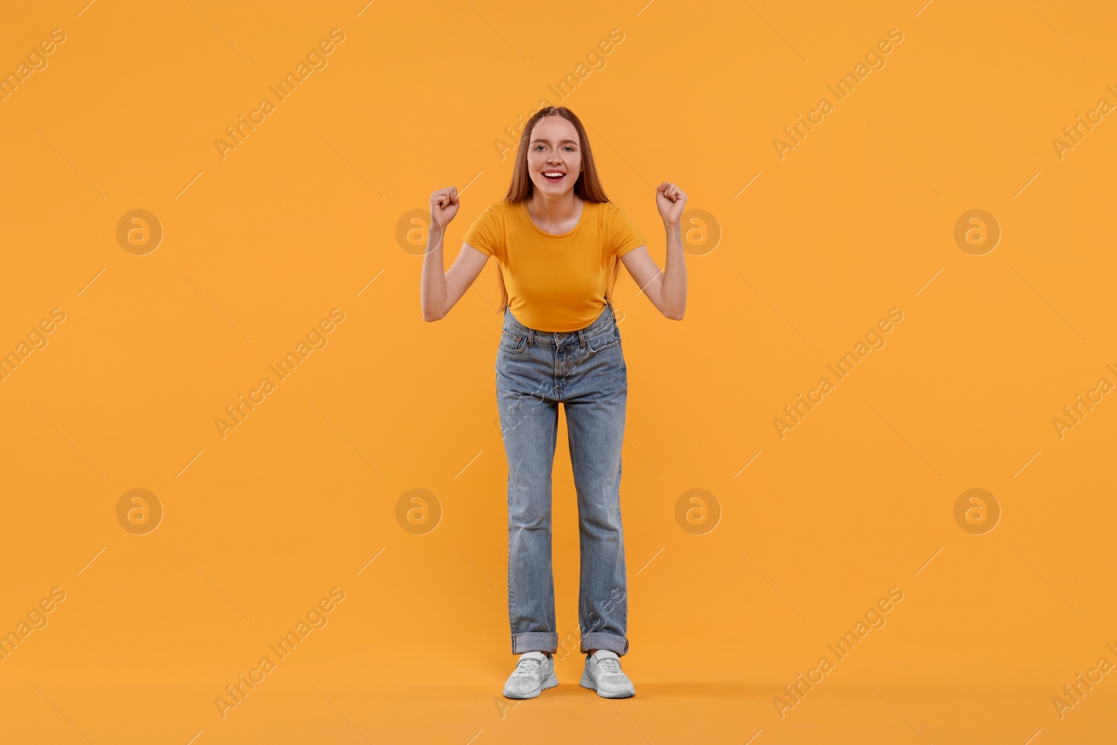 Photo of Emotional sports fan celebrating on yellow background